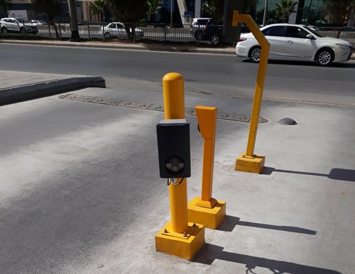 License plate recognition camera on a yellow bar, road in the background